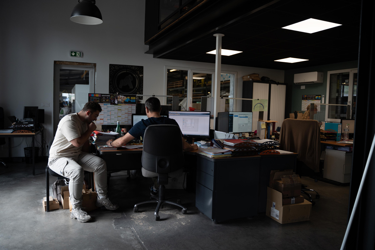 Deux personnes travaillant dans un bureau sombre.